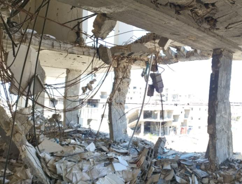Damaged columns and slabs with exposed reinforcement and debris inside the PMRS building